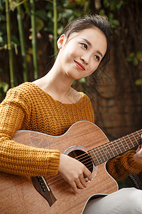 户外健康生活方式休闲装年轻女人弹吉他图片