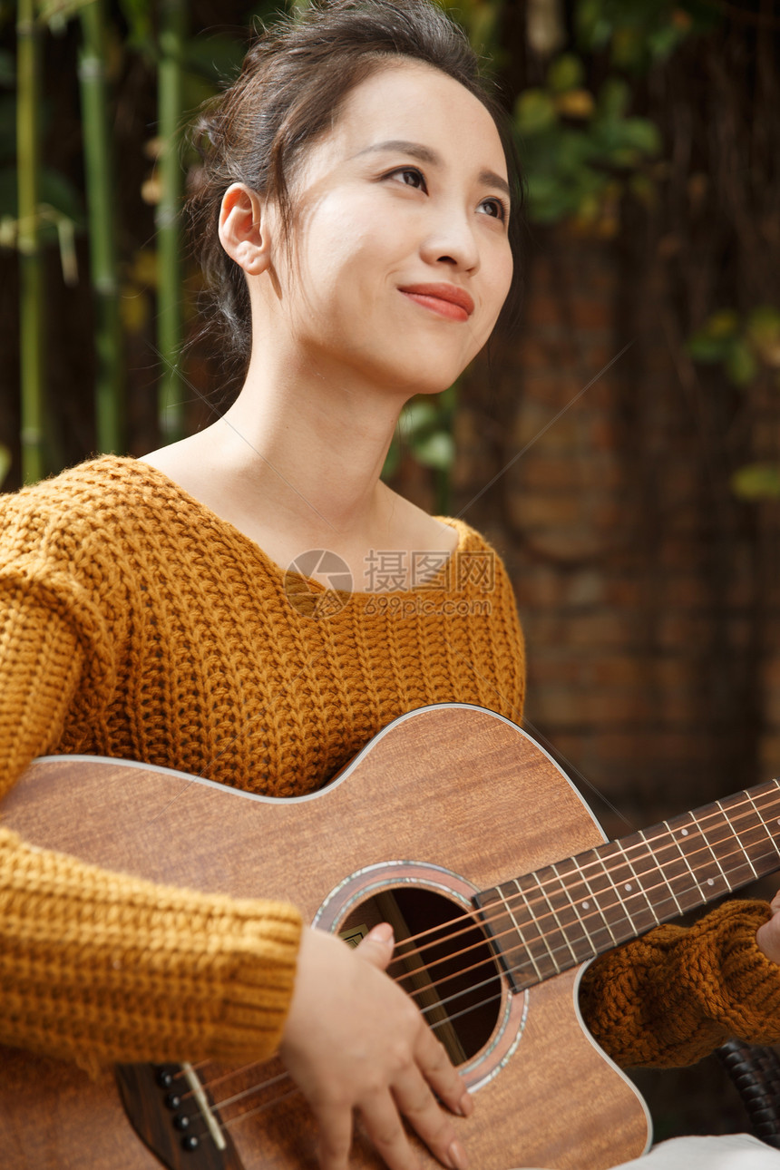 年轻女人弹吉他图片