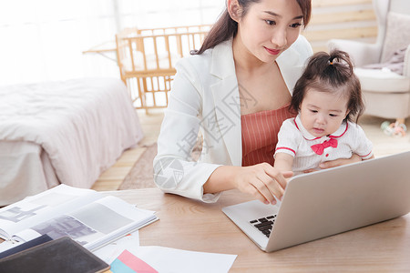 青年人亲情家庭生活年轻妈妈抱着孩子使用电脑图片
