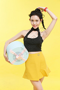 黄色背景短裙东方人时尚的青年女人图片