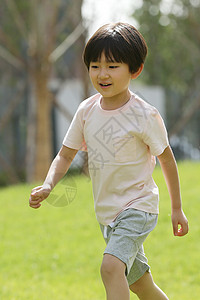 休闲装学龄前儿童户外小男孩在草地上玩耍图片