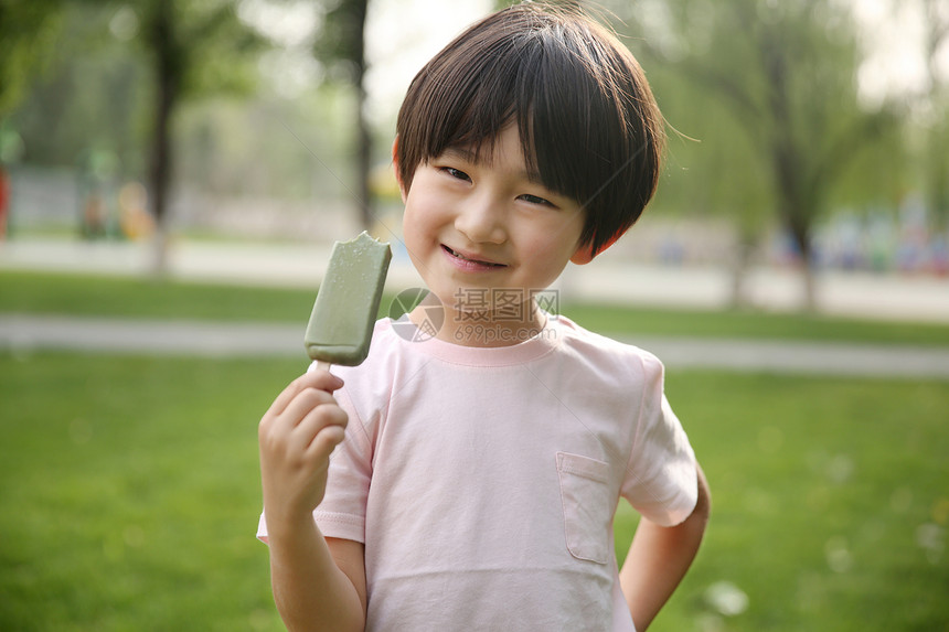 可爱的白昼亚洲人小男孩吃冰棍图片