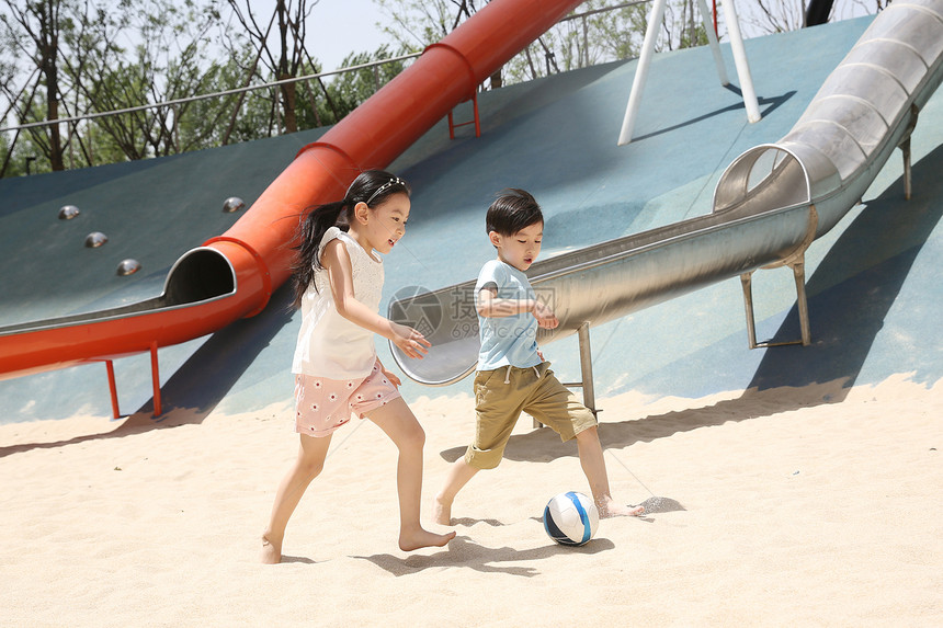 亚洲人人幸福儿童在沙子里踢球图片