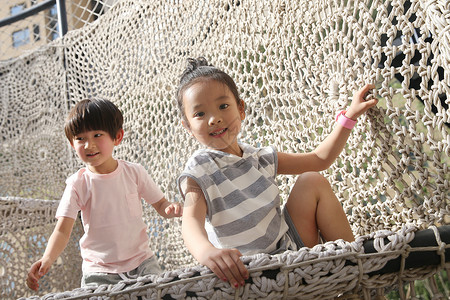 网编吊床可爱的摄影相伴快乐儿童在户外玩耍背景