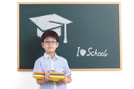 努力学习的孩子学龄儿童努力表现积极小学男生站在黑板前背景