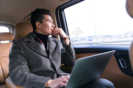 亚洲商务男人坐在汽车后座图片