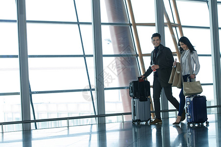 东方人航空业行李箱商务男女在机场图片