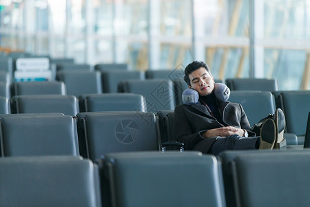 商务男性在高铁座位上休息商务旅行旅行航空商务男士在机场背景