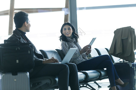 全球商务航空业笔记本电脑商务男女在候机大厅图片
