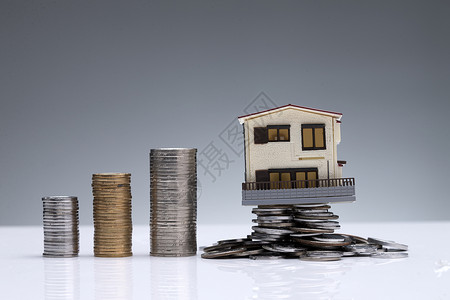 家庭财务硬币和房屋模型背景