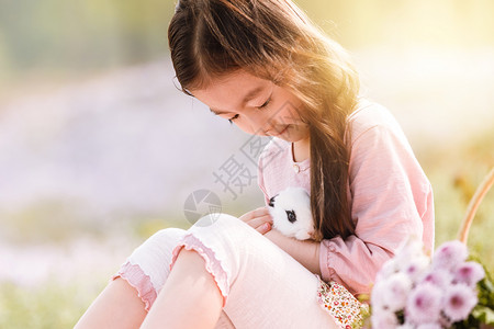 坐着兔子女孩儿童坐着放松可爱的女孩在户外背景