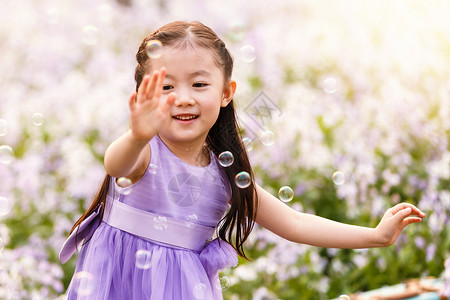 紫色抽象泡泡可爱的小女孩在户外背景
