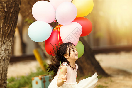 可爱的小女孩在户外玩气球图片
