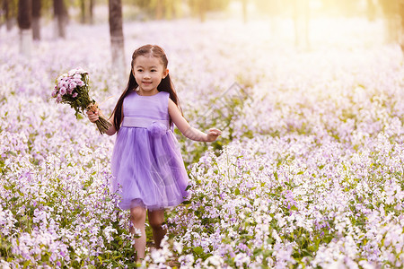 清新紫色花束长发二月兰可爱的小女孩在户外背景