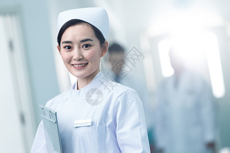 权威卫生服务年轻的女护士在医院走廊背景图片