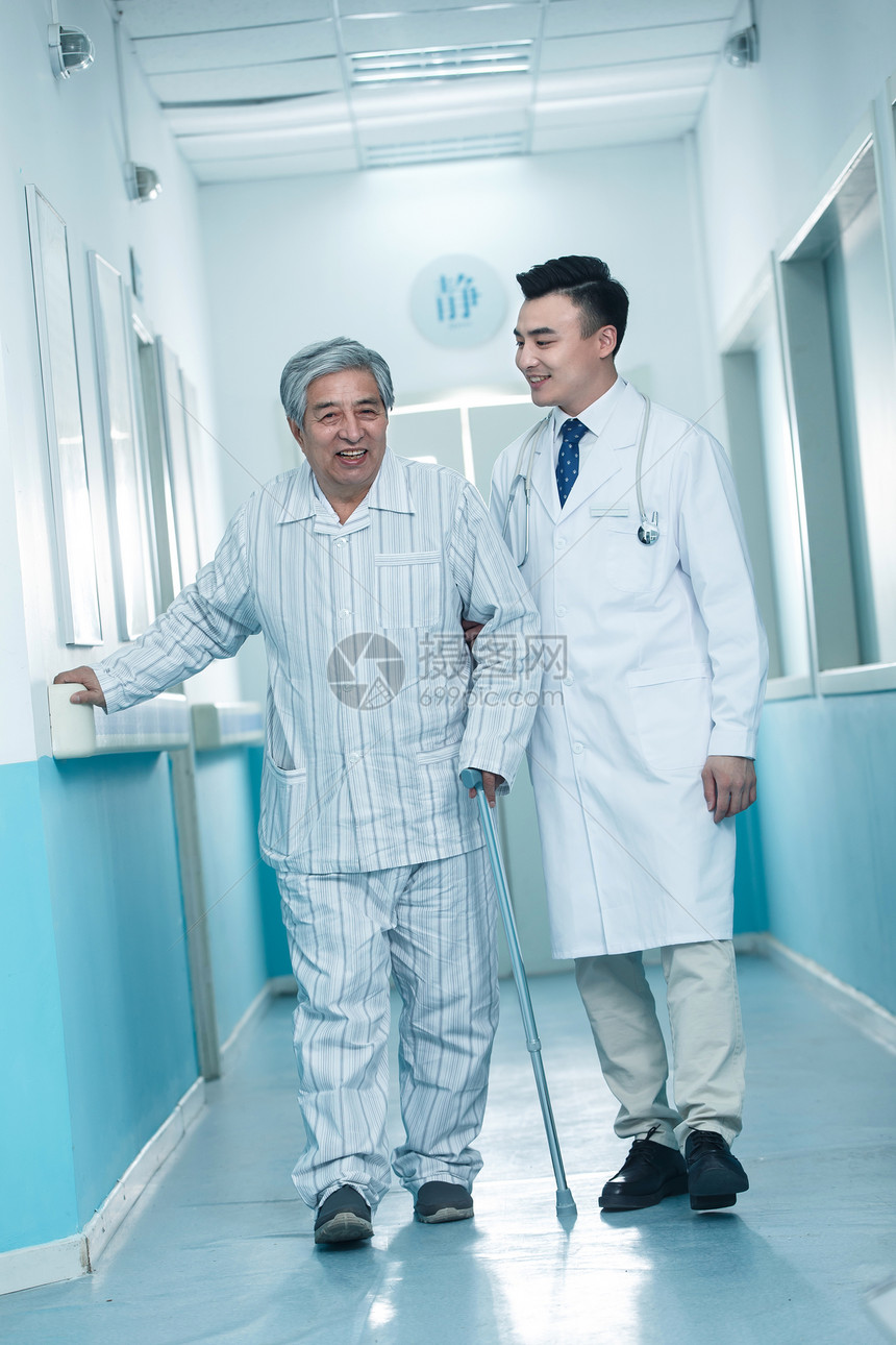 医生工作服专业人员全身像医生和老年男人在医院走廊图片