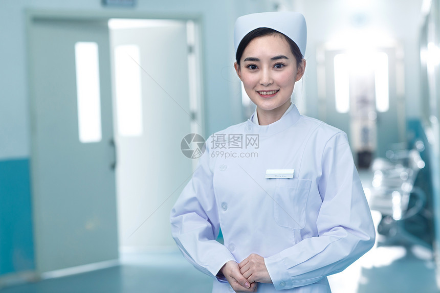 胸卡现代权威年轻的女护士在医院走廊图片