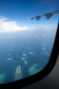 透过窗户往外看度假旅游从飞机上俯瞰马尔代夫风光高清图片