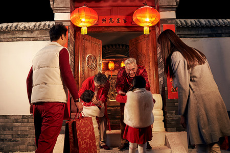 中国传统门灯光问候中年夫妇老人迎接孩子回家过年背景