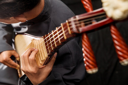 黑色中式花边专业人员中式衣领业余爱好男艺术家在弹琵琶背景