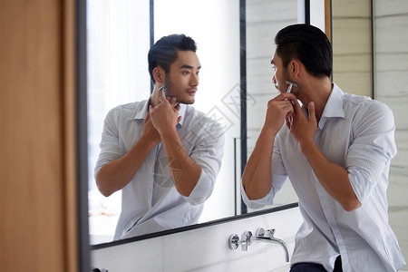 成熟男性对着镜子刮胡子高清图片