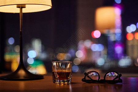 饮酒城市的夜晚窗前摆放的酒杯和眼镜背景