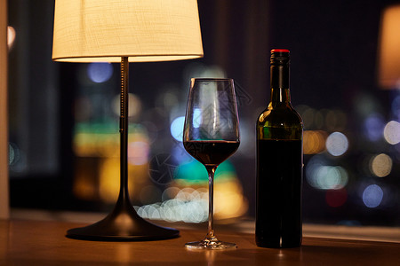 夜晚窗台边摆放的红酒高清图片