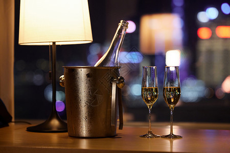饮酒城市夜晚桌子上摆放的香槟和杯子背景