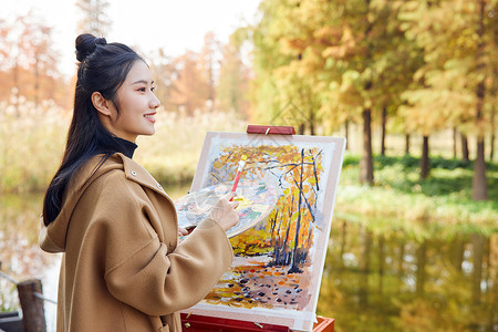 年轻女性秋季公园写生图片