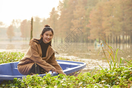 美女大学生秋游坐船形象背景图片