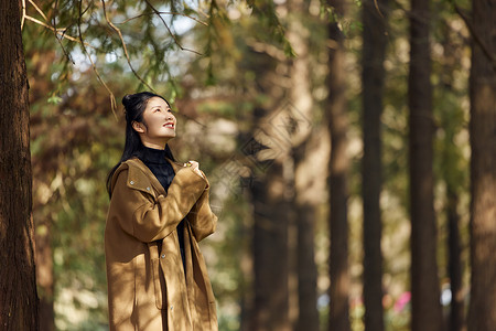 深秋树荫下的年轻美女图片