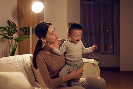 宝贝哭闹夜晚年轻宝妈安抚哭泣的宝宝背景