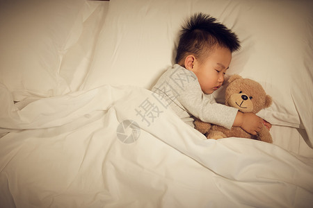 夜晚抱着玩偶熟睡的婴儿宝宝图片