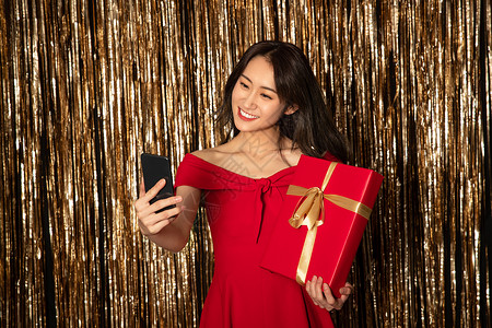 高兴的春节美女漂亮的青年女人拿着礼物背景图片