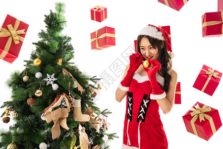 圣诞礼物长发时尚穿着圣诞服的年轻女人装饰圣诞树图片