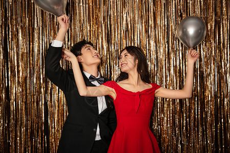 杂志金色红色黑色黑色伴侣高举手臂快乐嬉戏的幸福年轻情侣背景