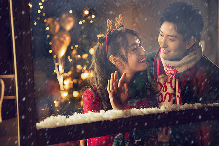 浪漫圣诞节快乐金色微笑时尚窗内的幸福情侣背景