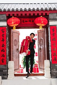 中式庭院春节木制的抱着礼物盒的青年男人图片