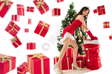 大袋庆祝圣诞树享乐穿着圣诞服的年轻女人和圣诞礼物背景