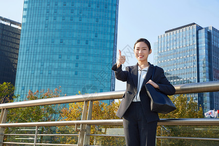 职场精英女性双手点赞形象商务女士户外点赞形象背景