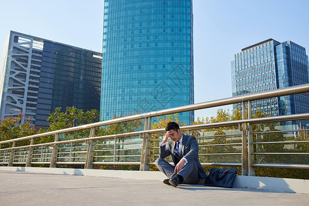 失业男士坐在天桥上图片