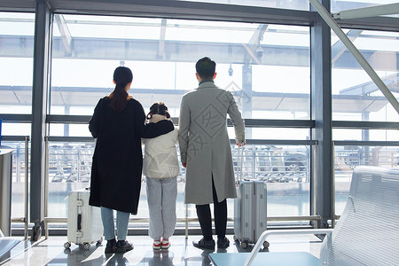 一家人机场出行提行李箱背影图片
