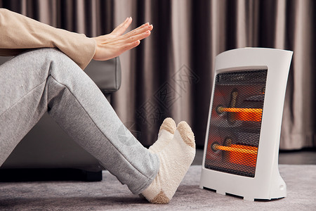 使用取暖器温暖手脚特写高清图片