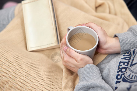 冬季女性居家看书喝咖啡特写图片
