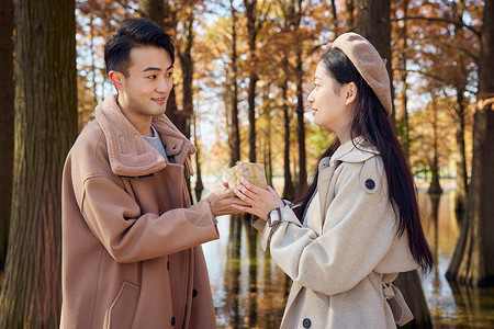 端茶送水秋冬青年情侣公园郊游男生送女生礼物背景