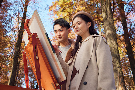 油画树林秋季户外情侣在公园里画油画背景