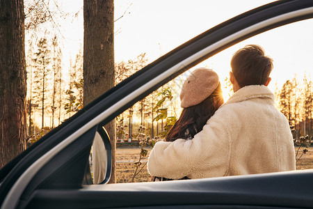 结伴出行夕阳下在车窗前拥抱的情侣背影背景