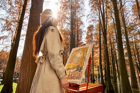 夕阳下的树林逆光下的秋冬美女户外画画背景