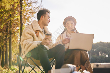 年轻情侣坐在户外休闲放松高清图片
