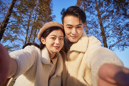 秋冬出游年轻情侣与镜头互动画面背景